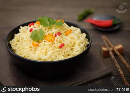 Still life instant noodles with pepper on wooden table, junk food or fast food concept.