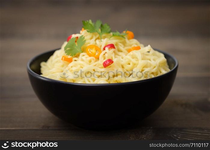 Still life instant noodles with pepper on wooden table, junk food or fast food concept.