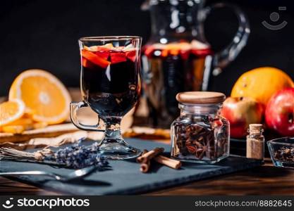 Still life - mulled wine, hot red wine with spices in glass among fruits. Scented cozy Christmas celebration, fragrant punch concept. High quality. Still life - mulled wine, hot red wine with spices in glass. Scented Christmas