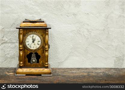 still life of antique clock on woolden plank and old concrete texture background using vintage tone Retro filter effect Soft focus Low light.(selective focus).