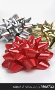 Still life of big shiny red, gold and silver Christmas bows.