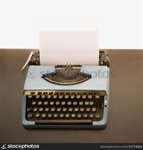 Still life of blank sheet of paper in an old fashioned typewriter.