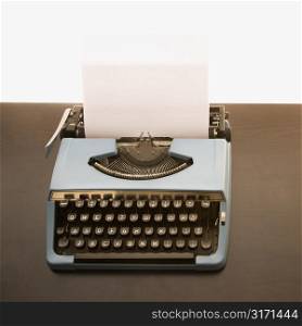 Still life of blank sheet of paper in an old fashioned typewriter.