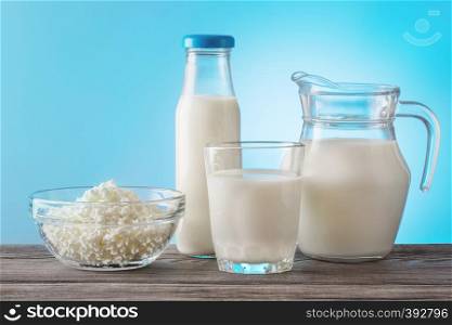 Still life of dairy products on wooden table with a blue background. The concept of healthy food.. Still life of dairy products on wooden table