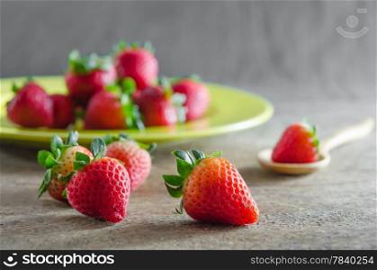 still life of fresh red strawberries on dish over wooden background. red strawberries