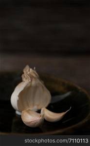 Still life of garlic bulb in dark black background with copy space, It is a herbal food popular Asian.