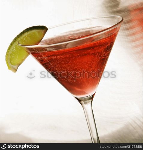 Still life of martini mixed drink with raspberry fruit agaisnt white background.