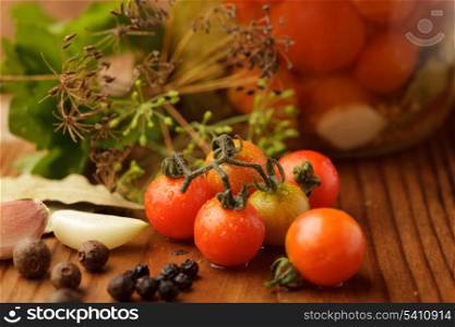 Still life of preserving tomatoes on wooden table in kitchen
