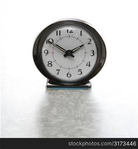 Still life of round vintage alarm clock on table.