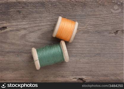 still life of spools of thread on a wooden background