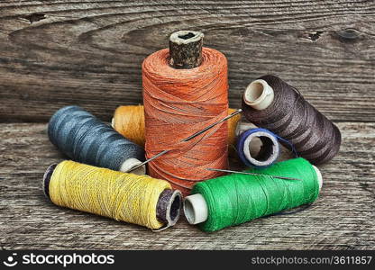 still life of spools of thread on a wooden background