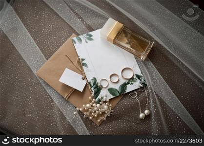 Still life of the wedding details of the ceremony.. Wedding jewelry, perfumes and envelopes with invitations on the table