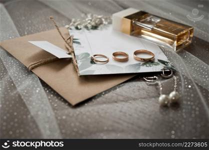 Still life of the wedding details of the ceremony.. Wedding jewelry, perfumes and envelopes with invitations on the table
