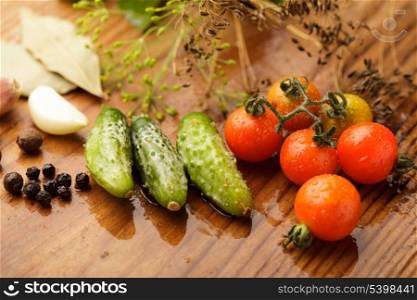 Still life of tomatoes and cucumbers on wooden table in kitchen