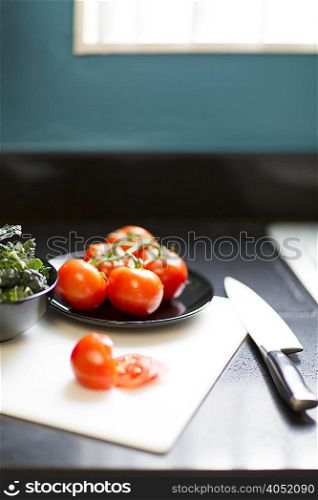 Still life of tomatoes, kale and knife on table