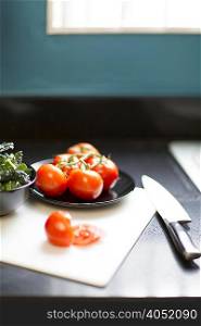 Still life of tomatoes, kale and knife on table
