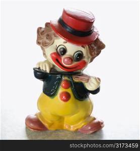 Still life of vintage colorful smiling clown figurine playing the violin.