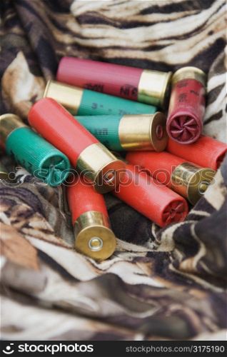 Still life shot of shotgun shells against camouflage clothing.