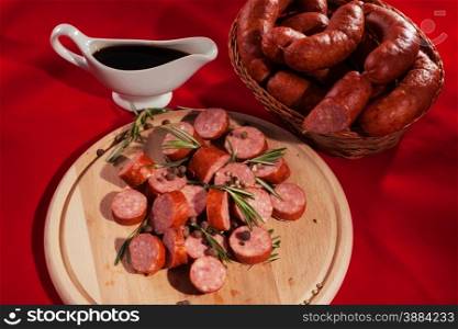 still life sliced sausages on a plate with rosemary, pepper and sauce
