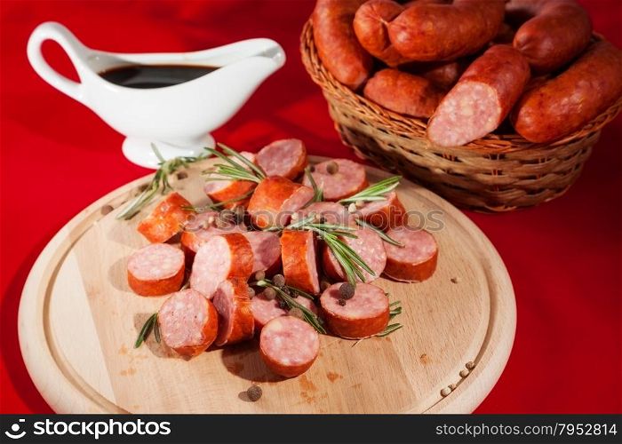 still life sliced sausages on a plate with rosemary, pepper and sauce