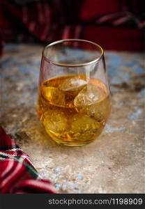 Still-life with a glass of bourbon. A glass of whiskey with ice. Concept of autumn spleen.