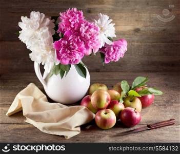 Still life with bouquet of peonies and red apples