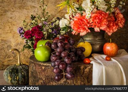 Still life with Fruits were placed together with a vase of flowers beautifully.