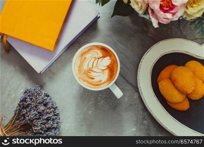 Still life with lavender and cappuccino cup with cookies and books. Cup of lavender cappuccino