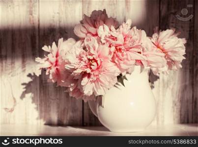 Still life with peonies over shabby wooden wall