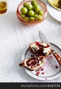 Still life with pomegranate and a bowl of green olives