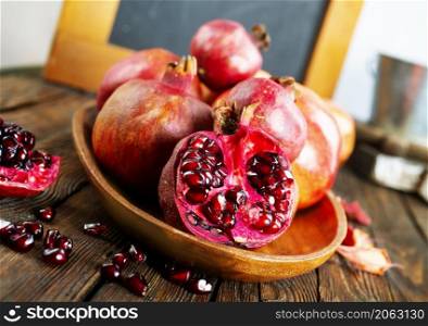 still life with red granates, pomegranates on wooden plate
