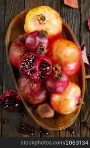 still life with red granates, pomegranates on wooden plate