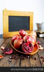 still life with red granates, pomegranates on wooden plate