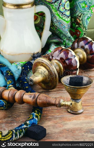 Still life with smoking hookah on wooden background. Smoking hookah is in the details