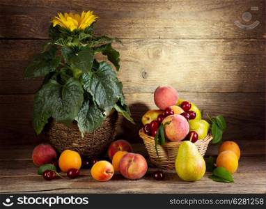 Still life with sunflower and fresh fruits wooden background