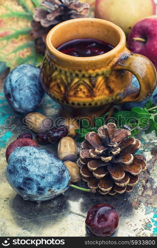 Still life with tea and fruit. Fashion clay cup on the background of harvest of autumn fruits.