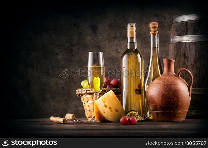 Still life with white wine and cheese on a brown background. Still life with white wine and cheese