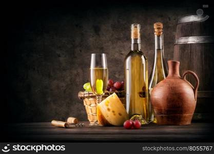 Still life with white wine and cheese on a brown background. Still life with white wine and cheese