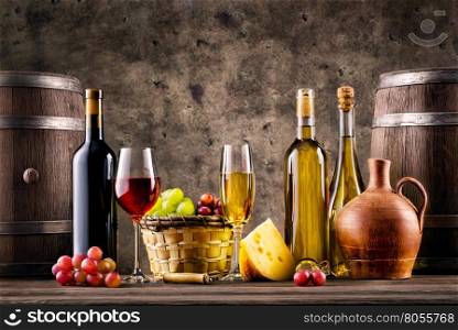 Still life with wine, grapes, barrels and cheese on grunge background