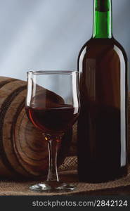 Still life with wineglass and bottle on the desk