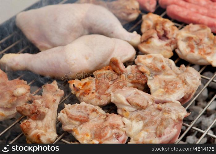 Stilts raw chicken cooking on the barbecue