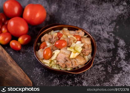 Stir cabbage with pork belly in a plate on a wooden plate.