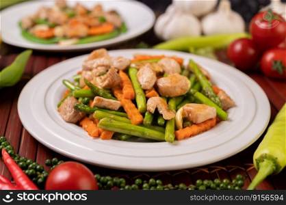 Stir-fried asparagus and carrots with pork in a white plate. Selective focus.