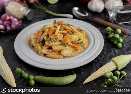 Stir-fried baby corn and carrots with minced pork in a white plate. Selective focus.