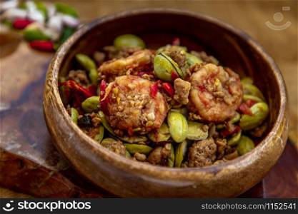 Stir Fried Bitter beans (Sator) with Shrimp in wooden bowl, It is a traditional food of southern Thailand, Spicy, stink bean, Selective focus.