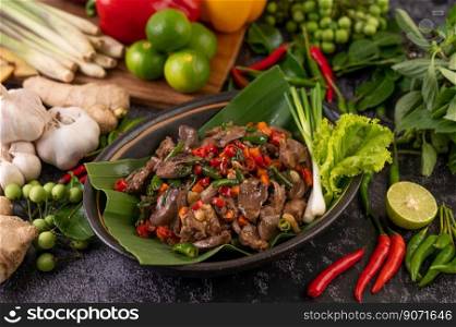Stir-fried chicken liver basil on banana leaves in a black dish. Thai food.