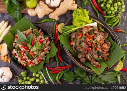 Stir-fried chicken liver basil on banana leaves in a black dish. Thai food.