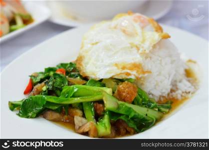 Stir-fried kale with crispy pork and fried egg on rice