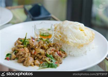 stir fried minced pork with chili , sweet basil served with steamed rice and fried egg