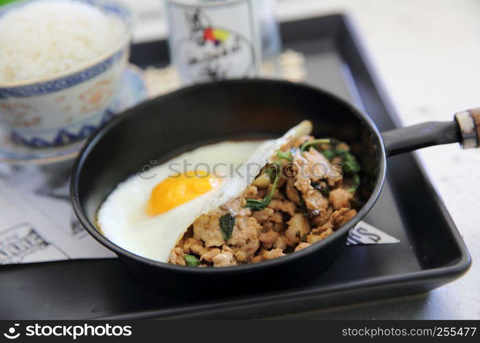 Stir fried pork and basil served with rice and fried egg , Thai food